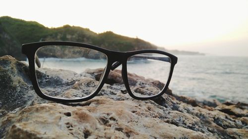 Close-up of eyeglasses on sunglasses at sunset