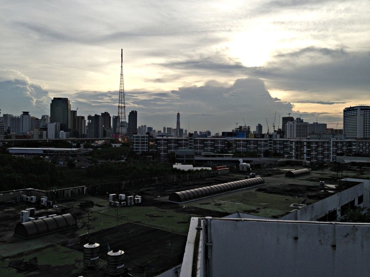 building exterior, city, architecture, built structure, cityscape, sky, skyscraper, cloud - sky, urban skyline, office building, tower, city life, high angle view, tall - high, residential district, skyline, cloud, sunlight, transportation, road