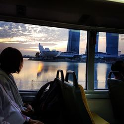 Rear view of woman looking through airplane window