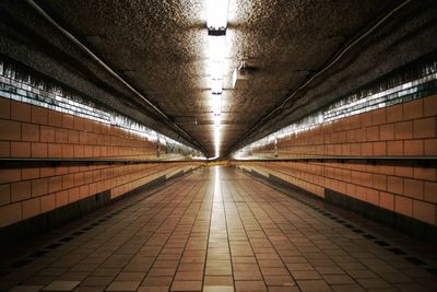 Interior of illuminated walkway at railroad station