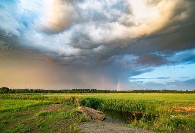 Rainbow with dramatic looking sky at the back of a severe thunderstorm over the dutch plains