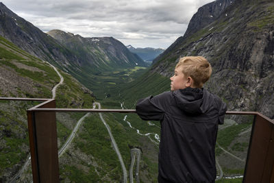 Rear view of boy looking at mountain valley