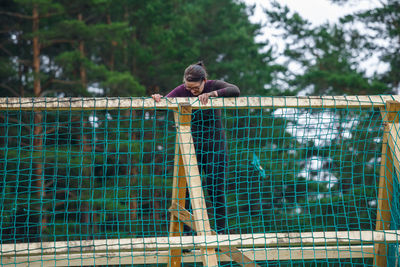 Full length of man playing on fence