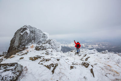 Rear view of man standing on snow covered landscape