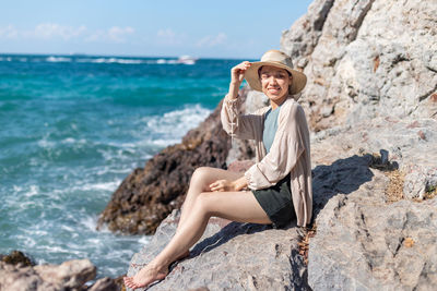 Woman sitting on rock at beach