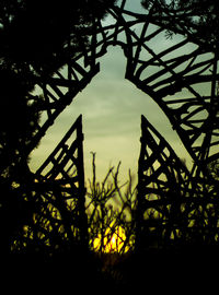 Low angle view of silhouette trees against sky