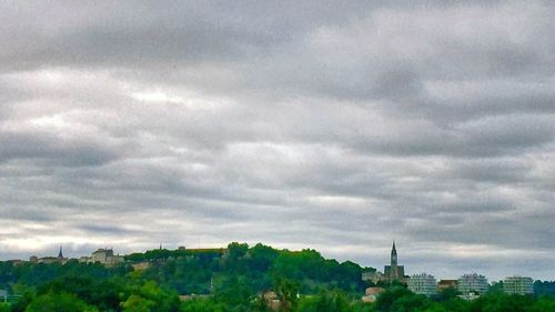 Cityscape against cloudy sky