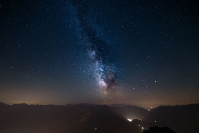 Scenic view of mountains against star field at night