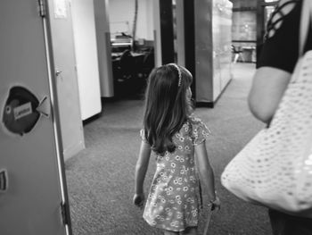 Rear view of girl standing in corridor