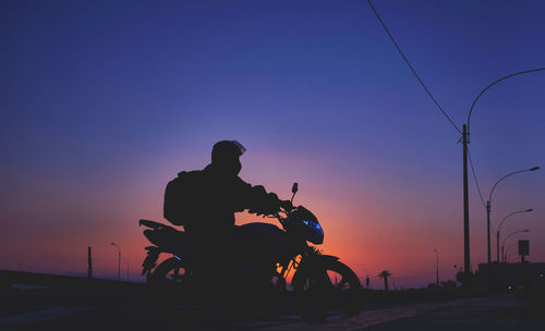 Night pizza delivery, man riding a motorcycle on the road at sunset. selective focus