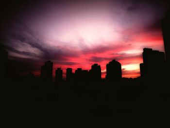 Silhouette buildings against sky during sunset