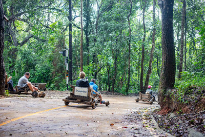 Rear view of people riding motorcycle on road