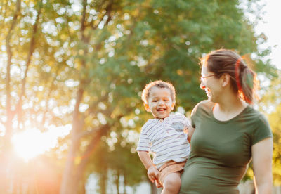 Mother and diverse mixed race toddler so. at park having fun bonding together