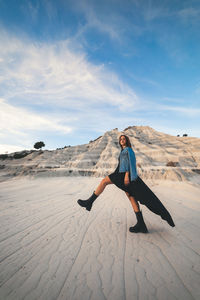 Full length of man skateboarding on desert against sky