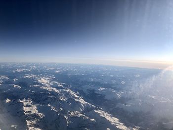 Aerial view of snowcapped mountains against clear sky