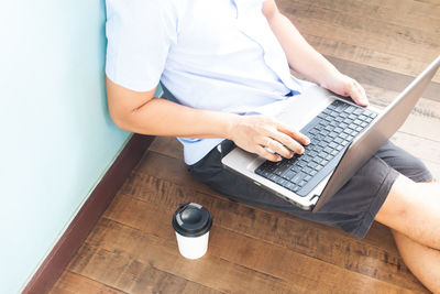 High angle view of man using mobile phone while sitting on table