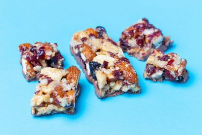 Broken pieces of protein bar on a blue background close-up.