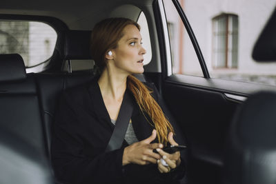 Businesswoman with brown hair sitting in car