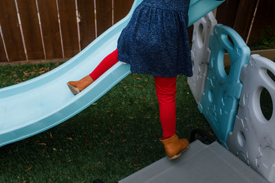 Low section of woman standing on car