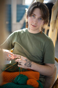 Portrait of young woman sitting on sofa at home