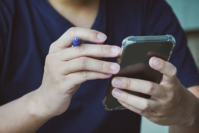 Midsection of man using mobile phone