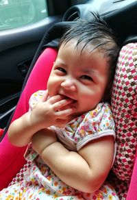 Portrait of cute smiling baby girl sitting in car