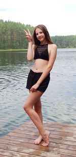 Portrait of woman smiling while standing by lake