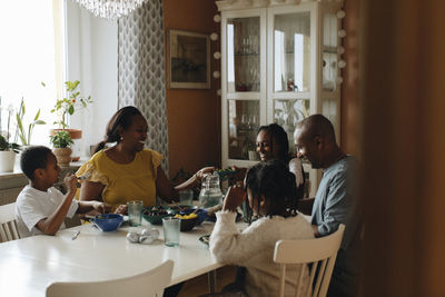 Family having lunch together while sitting at dining table