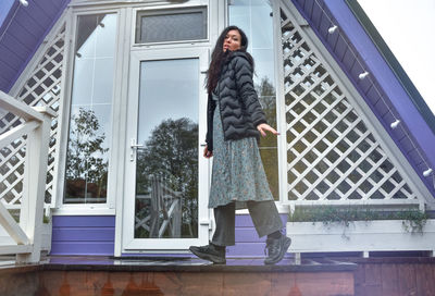 Rear view of woman standing against building