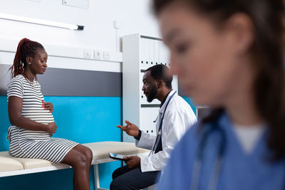 Side view of doctor examining patient at clinic