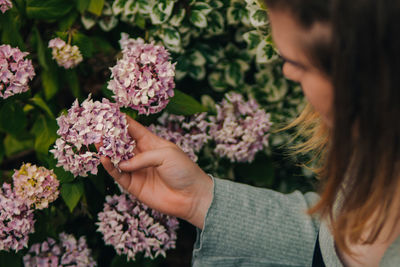 Woman holding pink flowering plants