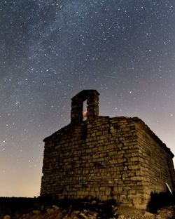 Low angle view of old ruined church against milkyway in the sky