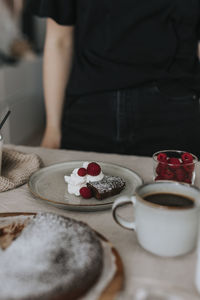 Serving of chocolate cake with cream and raspberries on plate