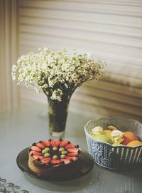 Strawberry and gooseberry cake with summer bouquet of daisies on summer morning 2020