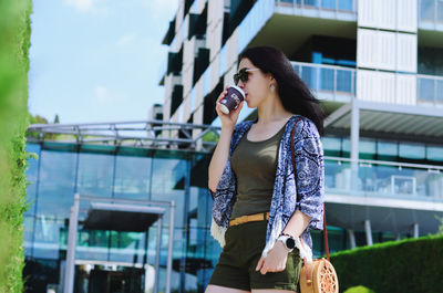 Young happy business woman relaxing in city, outdoor cafe. drinking coffee. using phone. summer