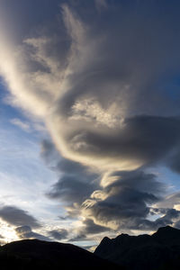 Low angle view of silhouette mountain against dramatic sky