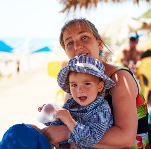 Portrait of mother and son sitting at beach