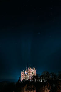 Illuminated building against sky at night