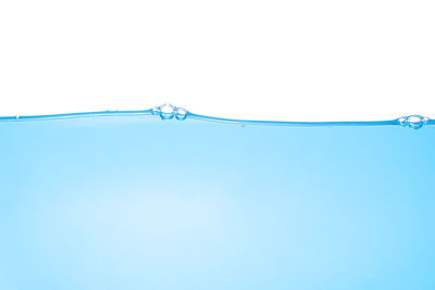 Close-up of water drop against blue sky