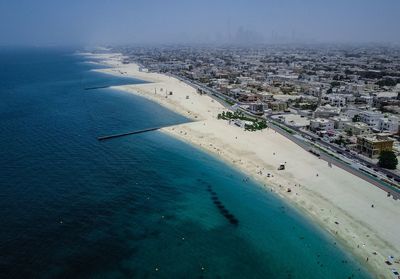 High angle view of cityscape by sea against sky