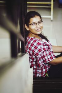 Portrait of smiling young woman sitting on steps