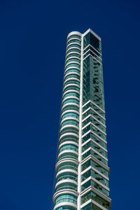 Low angle view of modern building against blue sky