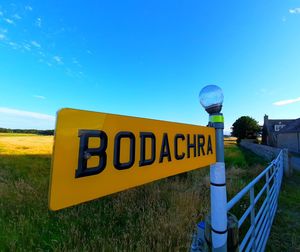 Information sign on field against clear sky