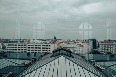 Modern buildings in city against cloudy sky