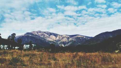 Scenic view of land and mountains against sky