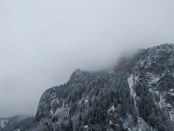 Low angle view of snowcapped mountains against sky