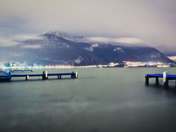 Pier over lake against cloudy sky