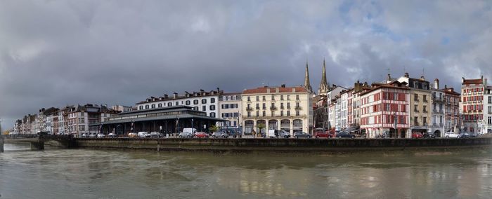 Panoramic view of river by buildings against sky