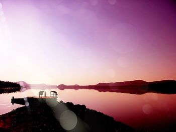 Scenic view of calm lake against clear purple sky