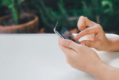 Closeup a woman's hand is using a smart phone to search for information online on the internet